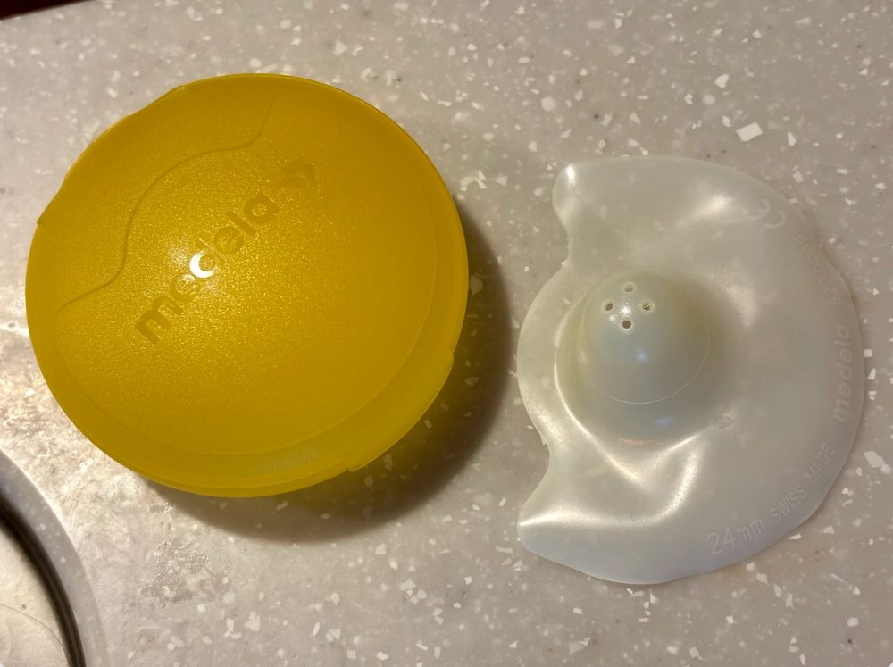 黄色い丸いケースと、白い乳頭保護器（24mm）